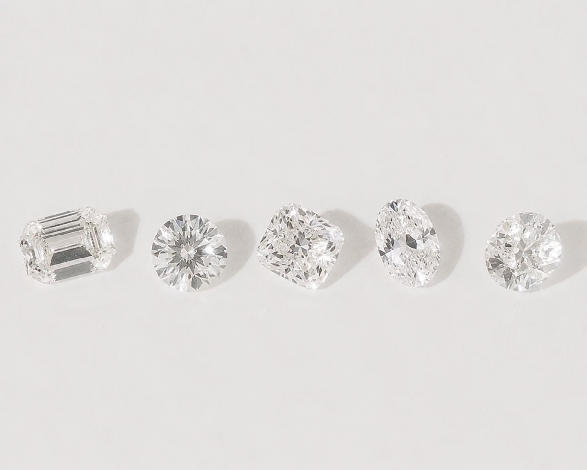 Cinq diamants de synthèse certifiés présentés sur fond clair : tailles émeraude, brillant rond, coussin et ovale, illustrant les différentes formes de diamants disponibles en joaillerie.